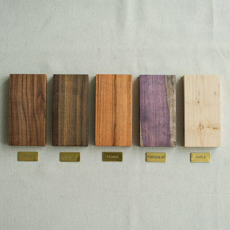 Collection of exotic hardwood lumber samples including rosewood, wenge, padauk, purpleheart and maple species