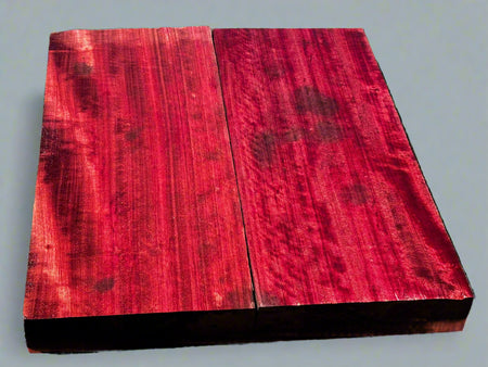 Two red wooden planks on a black surface