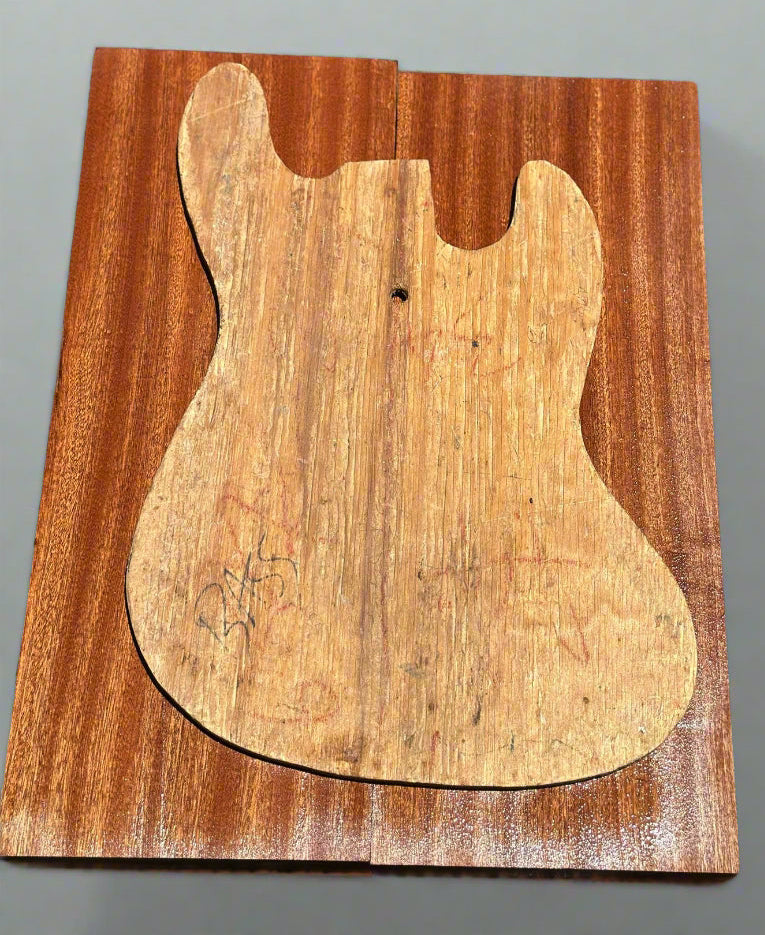 Wooden cutout of a guitar body on a dark surface